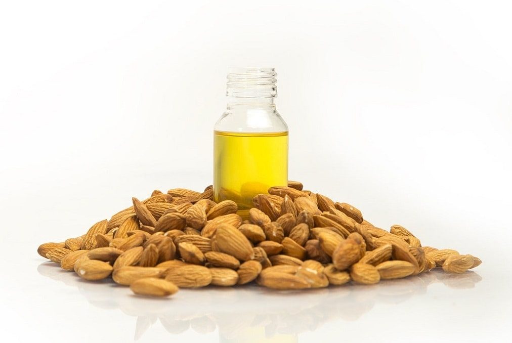 bottle of sweet almond oil surrounded by almonds