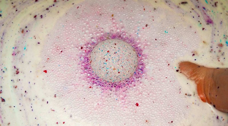 purple diy foaming bath bomb with rose petals in water
