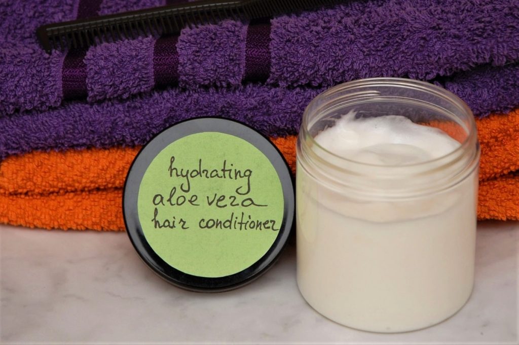 A jar with homemade hair conditioner next to towels
