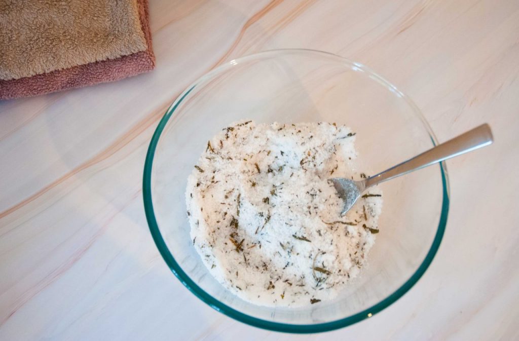 mixing all the ingredients for homemade tea tree foot soak for fungus in a glass bowl