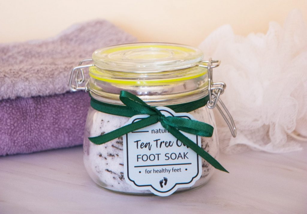 Homemade tea tree oil foot soak with epsom salt in the jar with a green gift tag