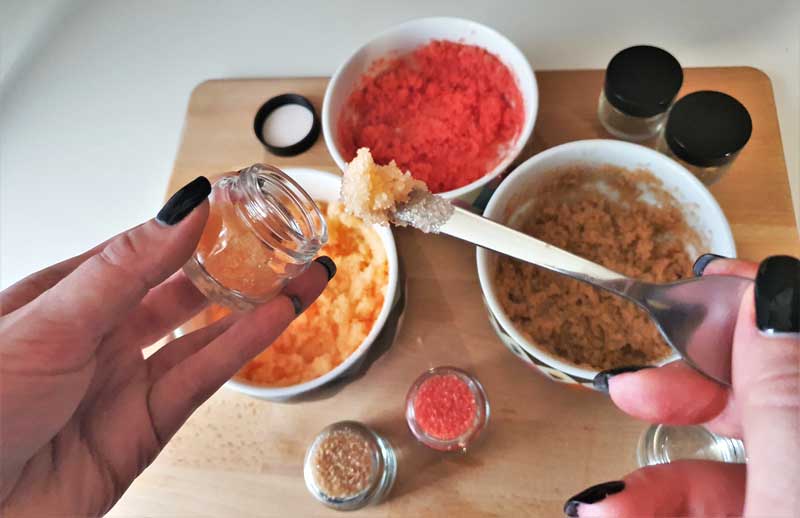 filling out small jars with DIY lip scrub