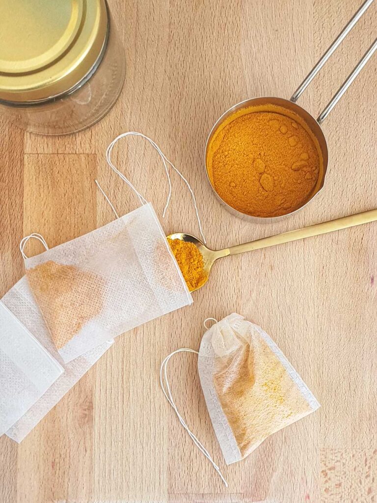 preparing turmeric powder for oil infussion by adding to empty tea bags 