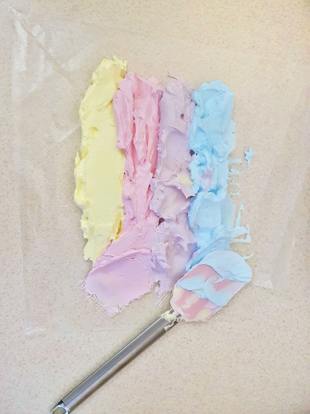 layering different colors of soap on a plastic sheet