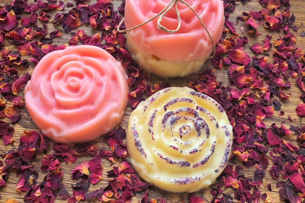 rose shaped and scented lotion bar recipe in pink and with rode petals